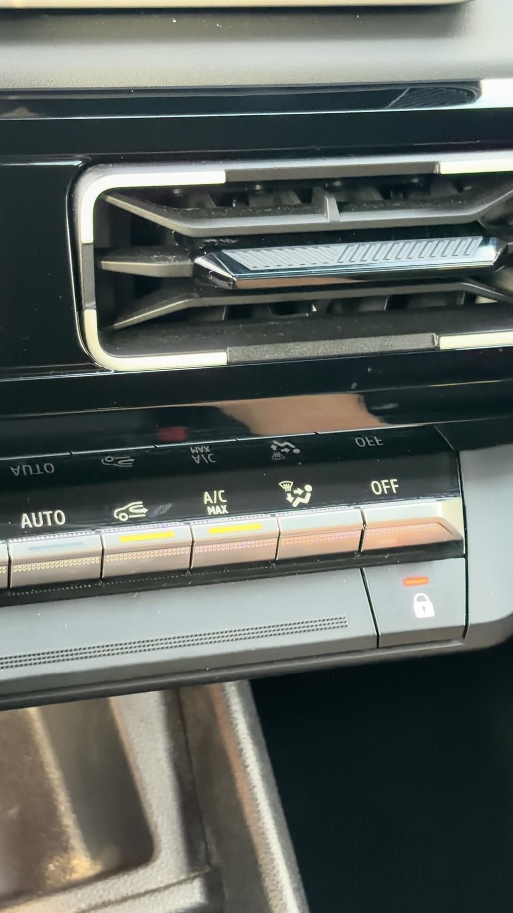 Botones físicos metalizados de la climatización del Renault 4 E-Tech con las funciones AUTO, recirculación, A/C MAX, desempañado y OFF