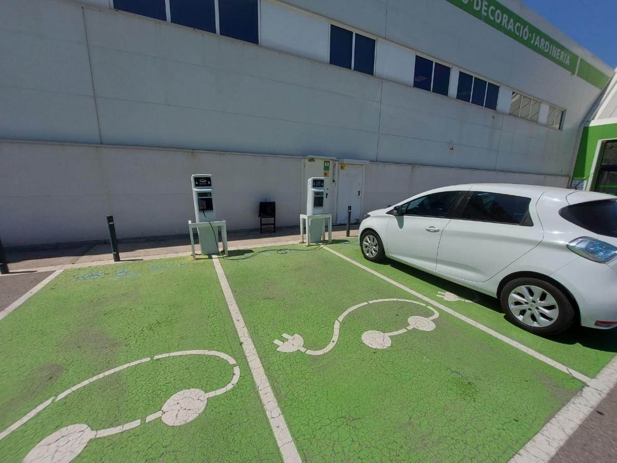 Dos columnas de recarga junto a la fachada de Leroy Merlin Sant Cugat, con plazas verdes y un Renault Zoe aparcado