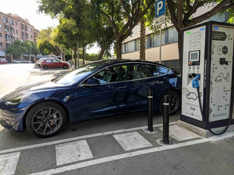 Tesla Model 3 azul cargando en el punto de recarga rápida de la calle de la Mina, en Sant Cugat