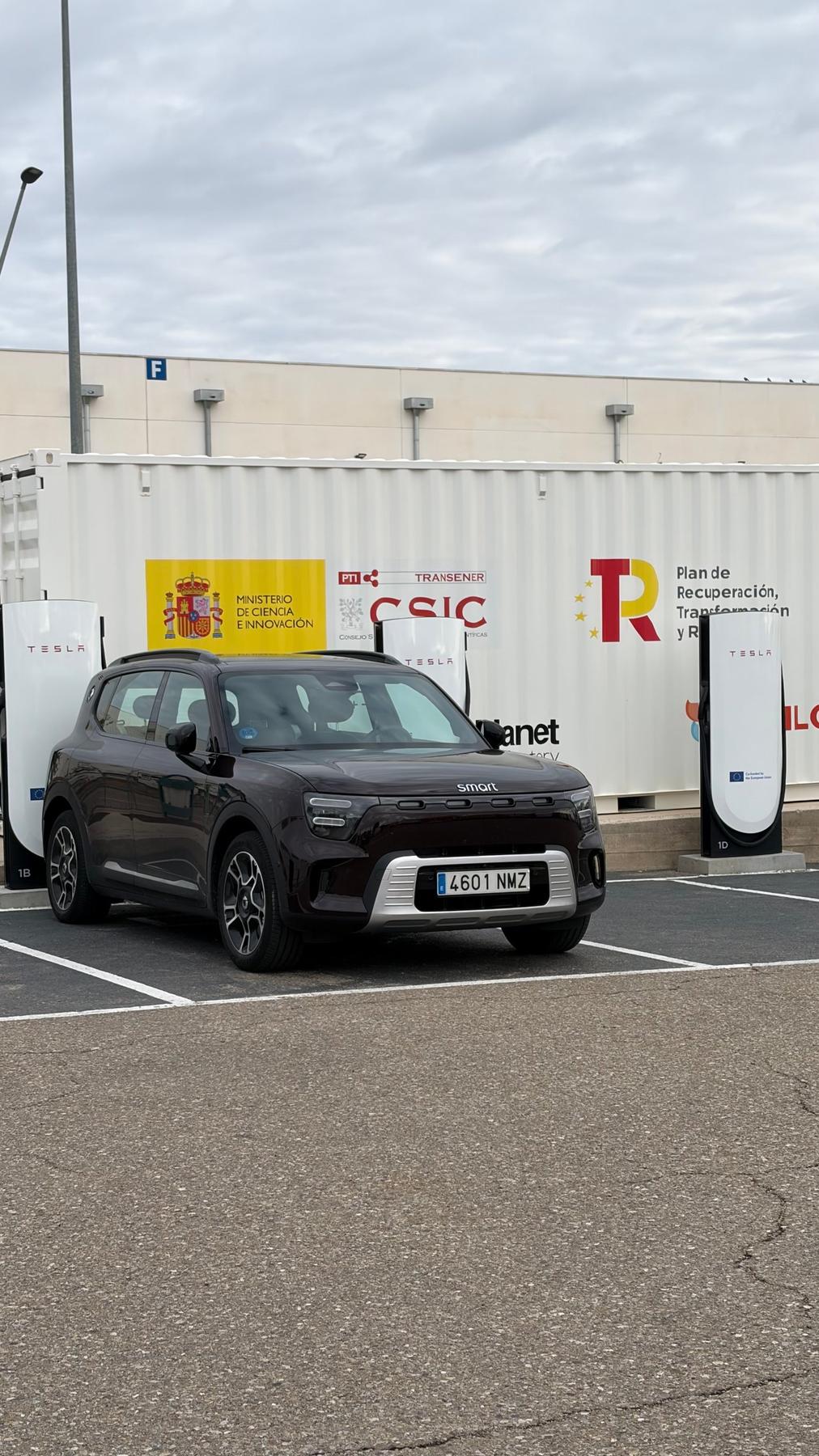 smart #5 Pro+ aparcado ante los Superchargers de Tesla de Zaragoza, con un contenedor blanco con el logotipo del CSIC detrás
